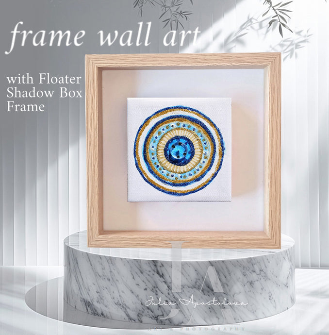 A colorful mandala-style artwork framed and displayed on a marble pedestal