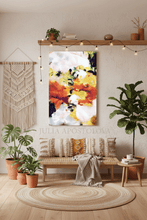 Cozy living room with a colorful abstract painting, plants, and a woven rug.