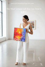Woman holding a colorful abstract painting in a bright room with a window.