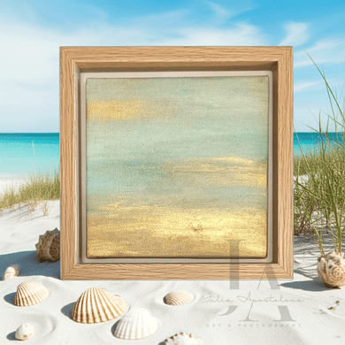 Framed artwork of a beach scene with shells on a sandy surface