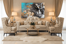 Luxurious living room with beige sofa, armchairs, and abstract art on the wall.