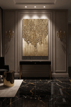 A large vertical gold-toned textured wall art piece mounted in a decorative interior hallway, with a dark console table beneath it, black marble flooring, wall sconces, and a visible watermark of the artist Julia Apostolova.