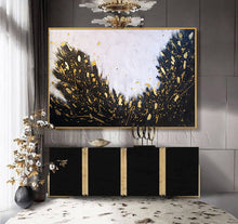 Abstract art painting with gold accents on a wall above a black cabinet. The black white gold abstract painting with lots of gold leaf is created by artist Julia Apostolova.