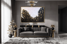 Modern living room with a gray sofa, gold lack decorative items, and black white gold abstract painting with lots of gold leaf by artist Julia Apostolova.