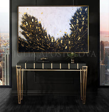 Modern interior with a console table and black white gold abstract painting in a room with cityscape views.