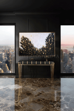 Modern interior with a console table and black white gold abstract painting in a room with cityscape views.