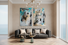 Modern living room with gold leaf abstract art set on the wall by artist Julia Apostolova, a gray sofa, and an ocean view