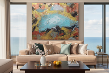 Modern living room with a large abstract painting above a beige sofa, and large windows with ocean view.