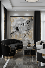 Modern living room with black and gold sofa, marble coffee table, and gray gold black abstract art on the wall, by artist Julia Apostolova. The painting's name is ''Milky Way', with lots of real gold leaf and beautiful hand-painted textures. 