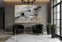 Large abstract canvas wall art with gold, white, gray, and black brushstrokes, displayed in a modern living room setting above two black armchairs.