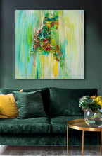 An abstract canvas painting with vibrant green, yellow, and brown brushstrokes hanging on a dark green wall above a matching green velvet sofa with yellow accent pillows.