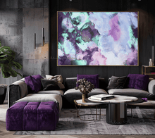Modern living room with a gray sectional sofa, purple cushions, and a colorful purple pink abstract painting on the wall.