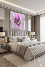 A luxury modern bedroom featuring a large framed abstract painting with pink, purple, and silver floral elements, hung above a tufted gray bed with neutral beige and white bedding.