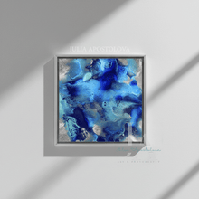 A square framed abstract art print featuring vibrant blue, teal, and silver fluid patterns, displayed on a light gray wall with artistic shadows.