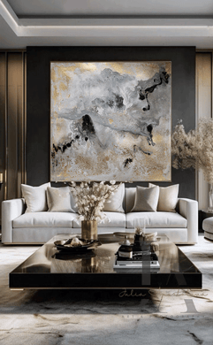 Modern Living room with large canvas in gray gold black and real gold leaf beautiful details, that shimmer under the different lighting, hanging over light colored couch , on dark gray wall, creating a glam atmosphere. The room features low modern coffee table and decorative elements, like vases candles and book. 