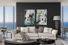 Modern living room with a gray sofa, abstract art on the wall, and large windows.