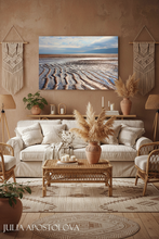 Cozy living room with coastal wall art, beige sofa, wicker coffee table, and decorative elements.