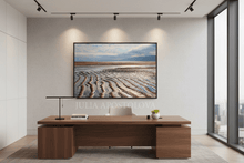 Modern office setup with a large coastal wall art of a scenic beachscape with sand ripples.