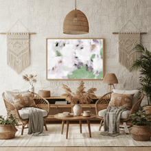 Cozy living room with wicker furniture, plants, and a floral painting.