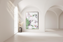 Framed floral artwork on a white wall in a minimalistic room with a vase below.