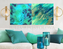 Two abstract turquoise paintings on a wall above a sofa with teal cushions and blue candle holders.