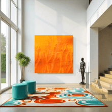 A modern and vibrant living room with a large orange abstract painting on the wall. The room has a colorful rug with orange and turquoise geometric shapes , and a large window overlooking the green scenery 
