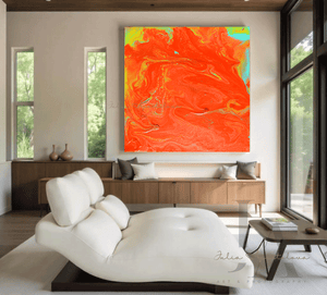 A large orange minimalist painting , displayed on white wall in a modern living room with a white sofa , a black low coffee table and a large window overlooking a natural landscape , creating a warm and inviting atmosphere
