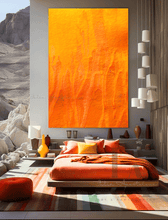 A modern and minimalist bedroom with a large orange abstract painting on the wall , a bed with orange sheets and oange and yellow pillows . The room has a cozy serene atmosphere, with a low platform bed, orange poof and wooden furniture, and natural elements like a vases , lamps , and a large window overlooking a natural rocky landscape .