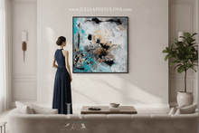 Woman in a blue dress standing in a modern living room looking at an large gold leaf abstract painting, by artist Julia Apostolova