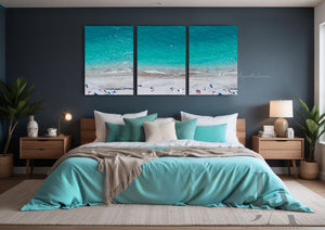 Aerial Beach Coastal Canvas Prints  Wall Art Decor, set of three, hanging over coach, in modern boho bedroom setting. The canvas art features People on the Beach, ocean Waves, white sand beach, and Turquoise Waters. The room has dark gray walls, a bed with turquoise blanket and dark teal and turquoise pillows, making cosy and relaxing atmosphere. 