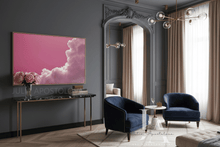 Modern living room with a pink cloud-themed painting on a dark wall.
