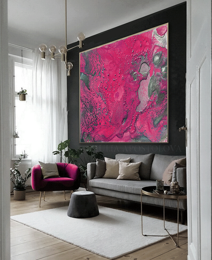 A modern and luxurious living room with a large gray sofa, fuchsia pink arm chair, and a very large fuchsia pink artwork on the wall with beautiful silver shinning details. The room has large windows, a low chrome table , a light gray carpet, and plush seating areas