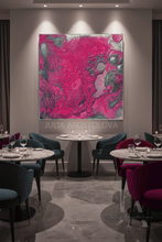 A large abstract wall art print featuring vibrant magenta pink, teal, and gray marbled patterns, displayed in a modern restaurant setting with dining tables and chairs.