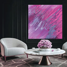 Living room with abstract pink and purple painting, gray armchair, and round coffee table.