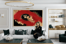 Woman sitting on a white sofa in a stylish living room with a large red black gold abstract painting.