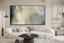 Modern living room with a white sofa, round black coffee table, and abstract painting on the wall.