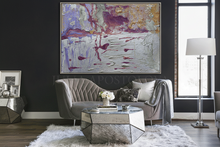 Modern living room with a gray sofa, abstract painting, and decorative items.