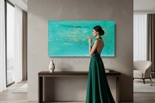 Woman in a datk teal dress standing in a modern living room with a large turquoise abstract painting on the wall by artist Julia Apostolova.