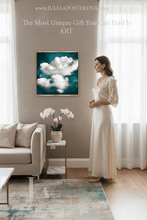 A woman in a cream dress stands in a bright living room next to a framed art print depicting white clouds against a deep teal sky. The image includes promotional text at the top.