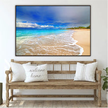Wooden bench with decorative pillows in a room with a large framed beach scene on the wall.