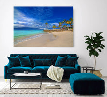 Living room with teal sofa, coffee table, and beach scene wall art.
