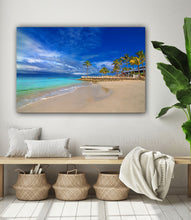Beach scene painting on a wall above a wooden bench with decorative items.