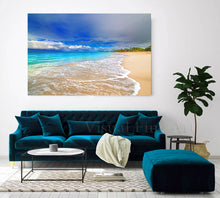 Living room with teal sofa, coffee table, and large beach scene painting on the wall.