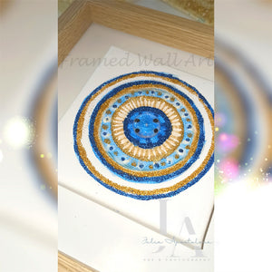 A mandala-style original painting, with glitter gold blue colors, in natural shadow box frame.  The painting canvas features small greek eye design in the center. Ideal art gift for Christmas, birthday, and any occasion. 