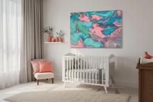 A colorful abstract canvas print with swirling teal, turquoise, and pink paint patterns, displayed on a light gray wall above a white wooden baby crib in a styled nursery room.