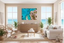 Modern living room with a large beach scene wall art,on the wall, white sofa, coastal decoration, wooden furniture, and large windows with ocean view.