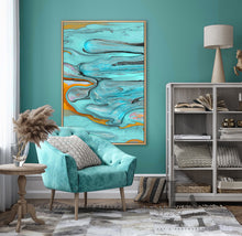 Abstract wall art by artist Julia Apostolova featuring swirling turquoise, teal, gray, black, and gold marbled patterns, displayed in a tall vertical frame on a teal wall above a teal turquoise velvet arm chair.