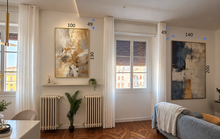 A styled interior room showing two large abstract wall art paintings hanging above radiators and beside windows. Blue dimension callouts with numbers are overlaid on the artwork and room measurements, suggesting this is an informational listing image rather than a pure product photo.