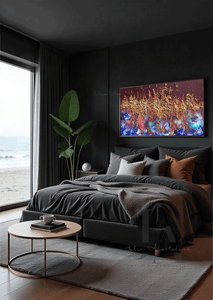 A modern dark bedroom, featuring a dark-grey, velvet bed, a low, round coffee table made of wood and gold metal, and a large colorful abstract painting with gold and copper rich 3d textures on the wall. The room overlooks a coastline through floor-to-ceiling windows. The setting sun casts a warm, natural glow across the scene.
