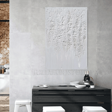 Abstract textured painting on a gray wall above a dining table with white chairs.